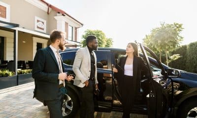 Car salon, sale and rent concept. African and Caucasian men in business wear buying the car. Elegant